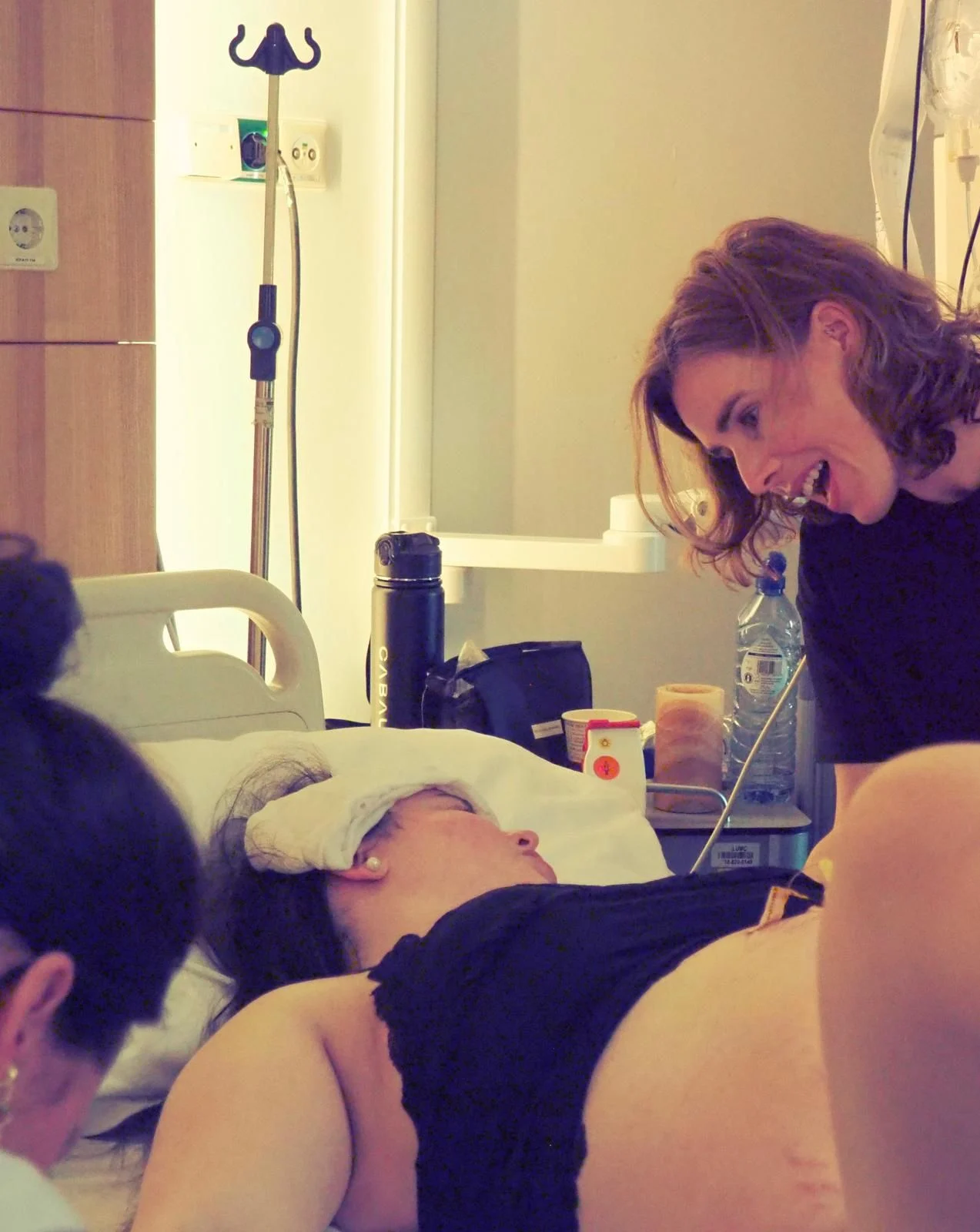 Een vertrouwd gezicht op de verloskamer Doula Iris lacht bemoedigend naar een barende vrouw op de verloskamer in het ziekenhuis